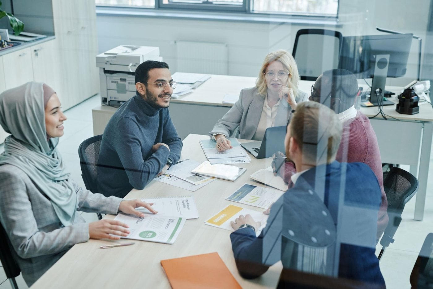 Equipo de trabajo revisando documentos en una mesa de reuniones